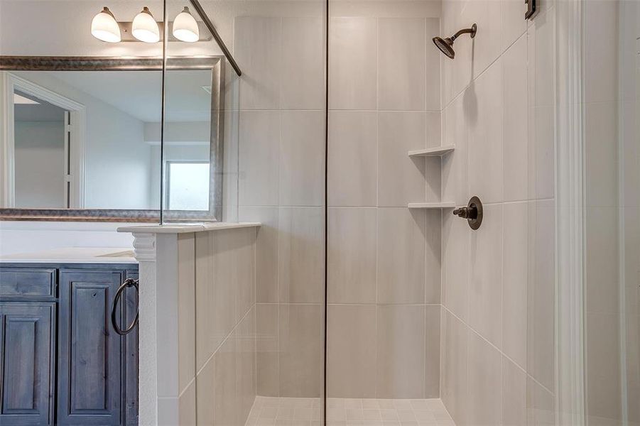 Bathroom with vanity and a tile shower