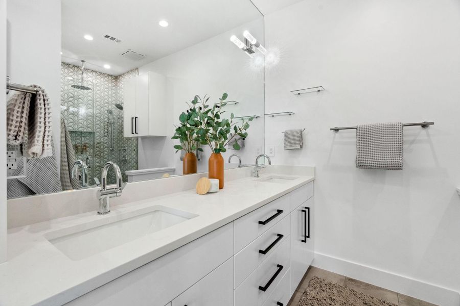 This expansive second primary bath features dual sinks and a spacious shower.