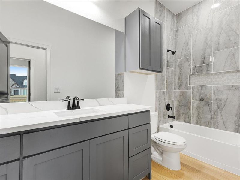 Bathroom featuring shower combination, vanity, and light wood-style floors Bathroom featuring shower combination, vanity, and light wood-style floors