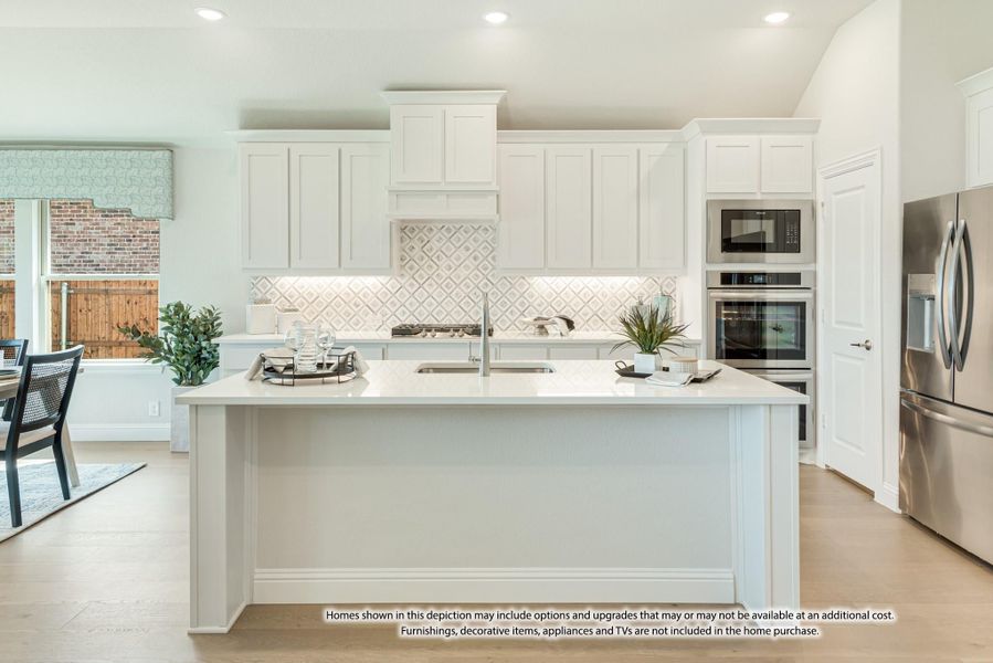 Kitchen with white cabinets, patterned tile backsplash, center island with sink, and stainless steel appliances on light wood floors Kitchen with white cabinets, patterned tile backsplash, center island with sink, and stainless steel appliances on light wood floors