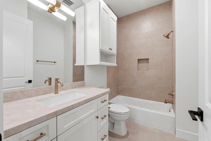 Bathroom #7 (Attached to FLEX ROOM) Featuring a shower/ tub combo, WHITE cabinets, gold hardware, MODERN light fixture, and SPA- like inspired tile.