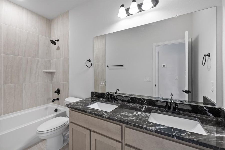 Bathroom featuring shower / washtub combination and double vanity
