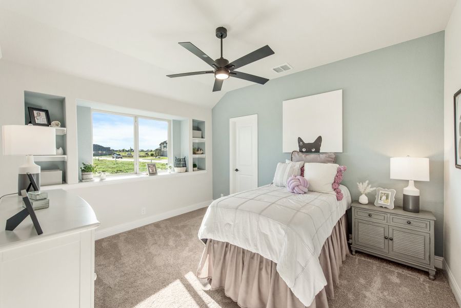 Bedroom with light blue walls, ceiling fan, built-in shelves, and carpet flooring