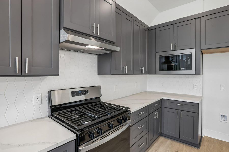This stunning kitchen features,quartz counters, SS appliancesthat include a gas range and apantry.