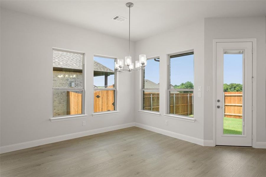 Unfurnished dining area featuring a chandelier and wood finished floors Unfurnished dining area featuring a chandelier and wood finished floors