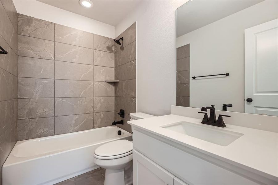 Full bathroom featuring toilet, vanity, shower / washtub combination, tile patterned flooring, and recessed lighting Full bathroom featuring toilet, vanity, shower / washtub combination, tile patterned flooring, and recessed lighting