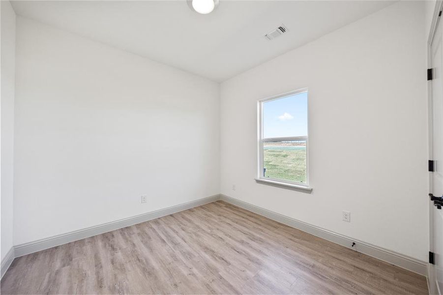 Empty room with light wood finished floors and baseboards