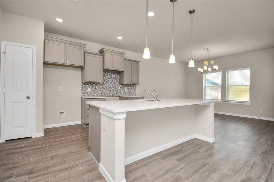 The expansive granite countertops offer an abundance of prep and serving space, perfect for creating culinary delights or entertaining a crowd. *This image is from another Saratoga Home with similar floor plan and finishes, not the Brittany floorplan.*