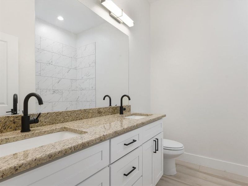 Full bathroom featuring double vanity and light wood-style flooring