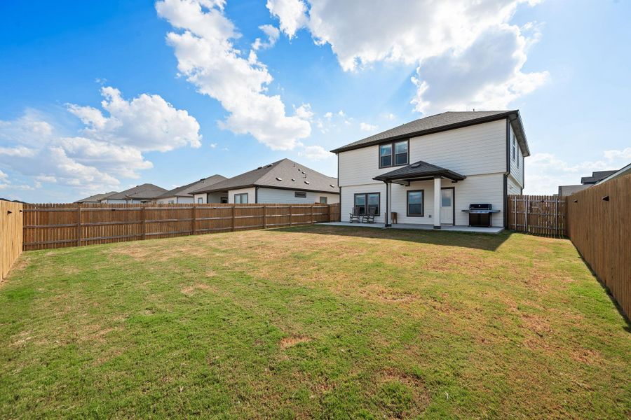 A spacious, fully fenced lawn surrounds the back of this two-story home. A spacious, fully fenced lawn surrounds the back of this two-story home.