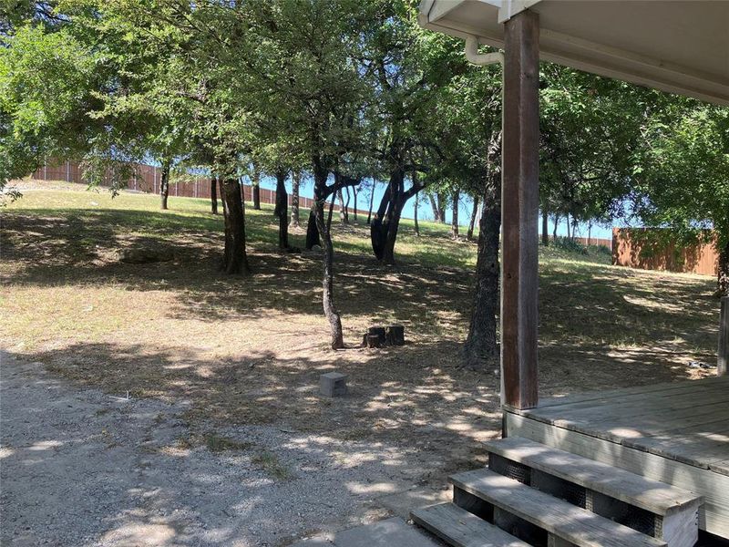 View of yard with a deck. Looking up to the road