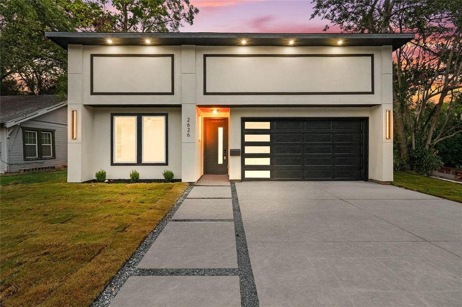 Contemporary house with concrete driveway, a front yard, and stucco siding Contemporary house with concrete driveway, a front yard, and stucco siding