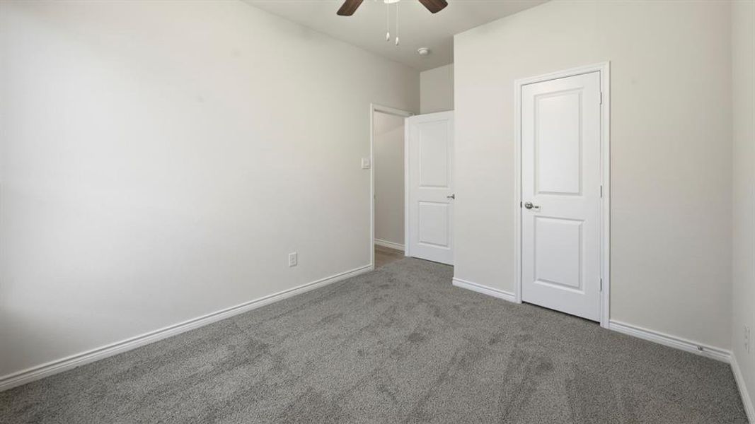 Unfurnished bedroom with carpet and a ceiling fan