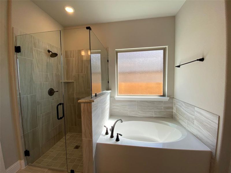 Master bath has separate garden tub and shower with dropped pan & frameless glass surround