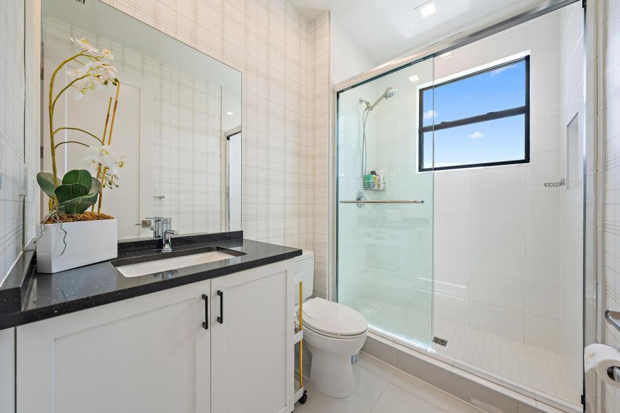 Upgraded shower, vanity, and custom wallpaper.