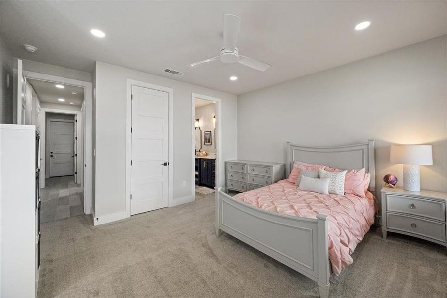 Bedroom with light carpet, a ceiling fan, recessed lighting, and connected bathroom