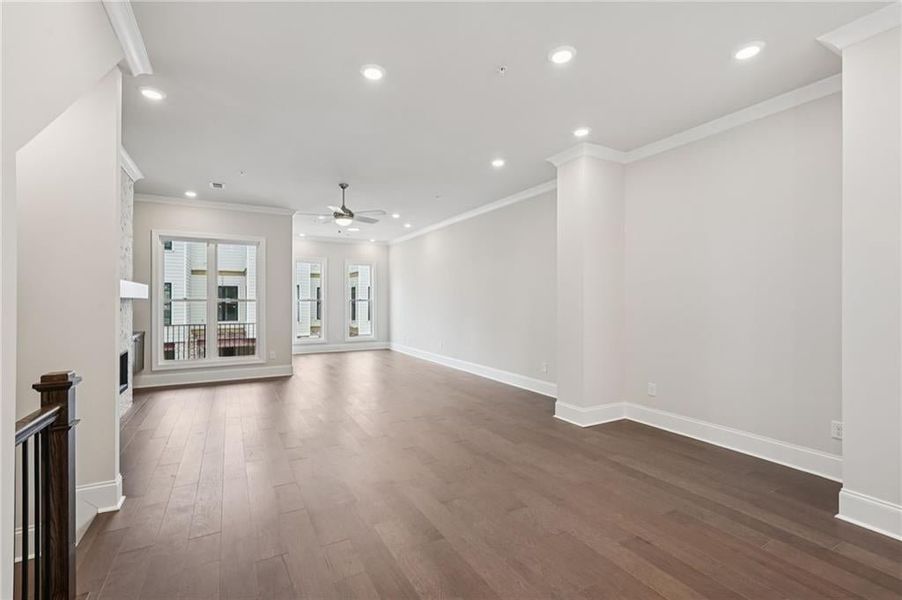 Unfurnished living room with recessed lighting, ornamental molding, a fireplace, dark wood finished floors, and ceiling fan
