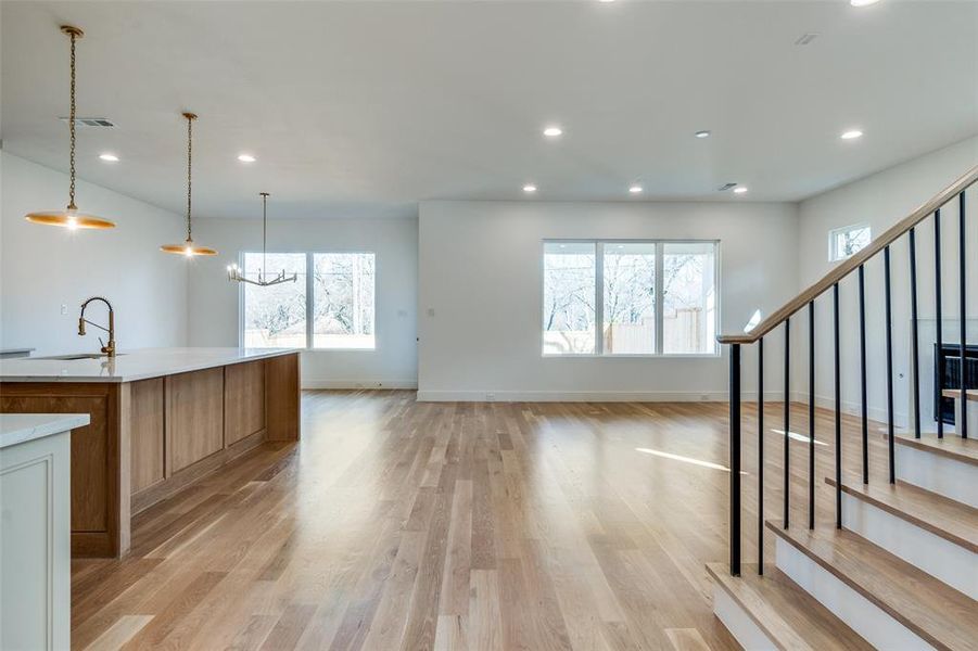 Kitchen featuring a large island, sink, a wealth of natural light, and hanging light fixtures