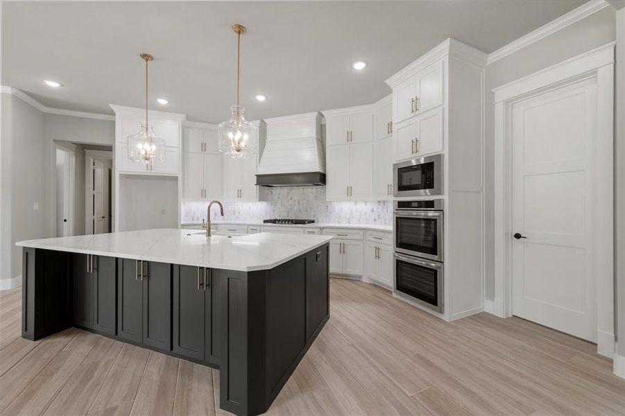 Spacious kitchen featuring a large central island with dark cabinetry and a light countertop