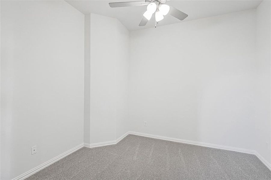 Carpeted spare room with ceiling fan