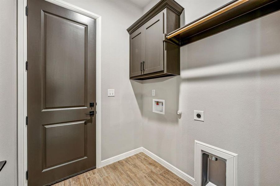 Clothes washing area featuring hookup for a washing machine, cabinets, electric dryer hookup, and light wood-type flooring