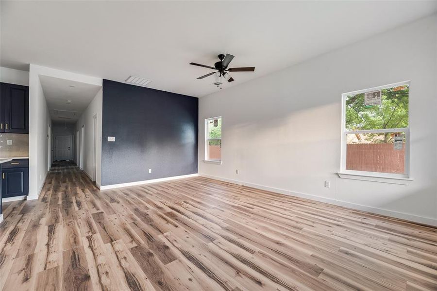 Unfurnished living room featuring ceiling fan and light wood finished floors