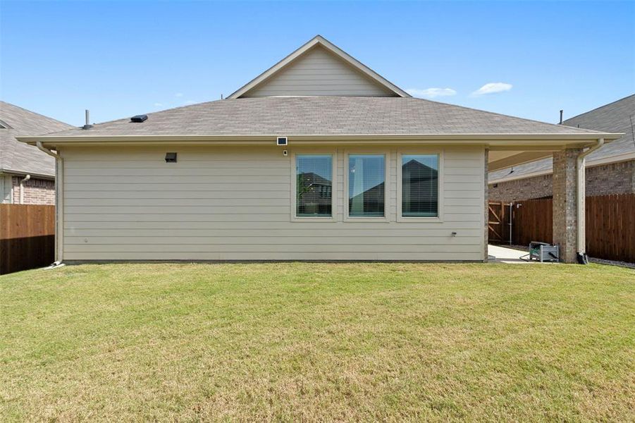 Rear view of property with a yard