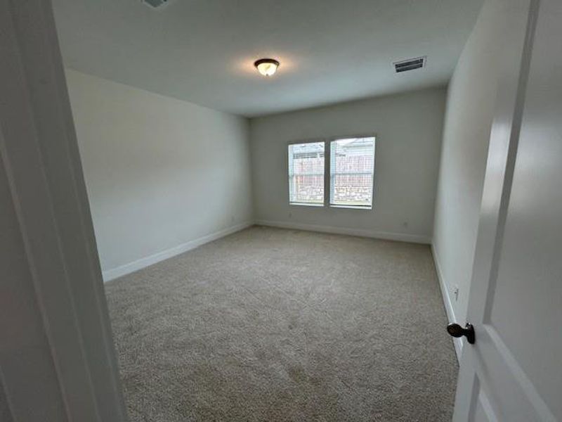 Unfurnished room featuring visible vents, carpet, and baseboards