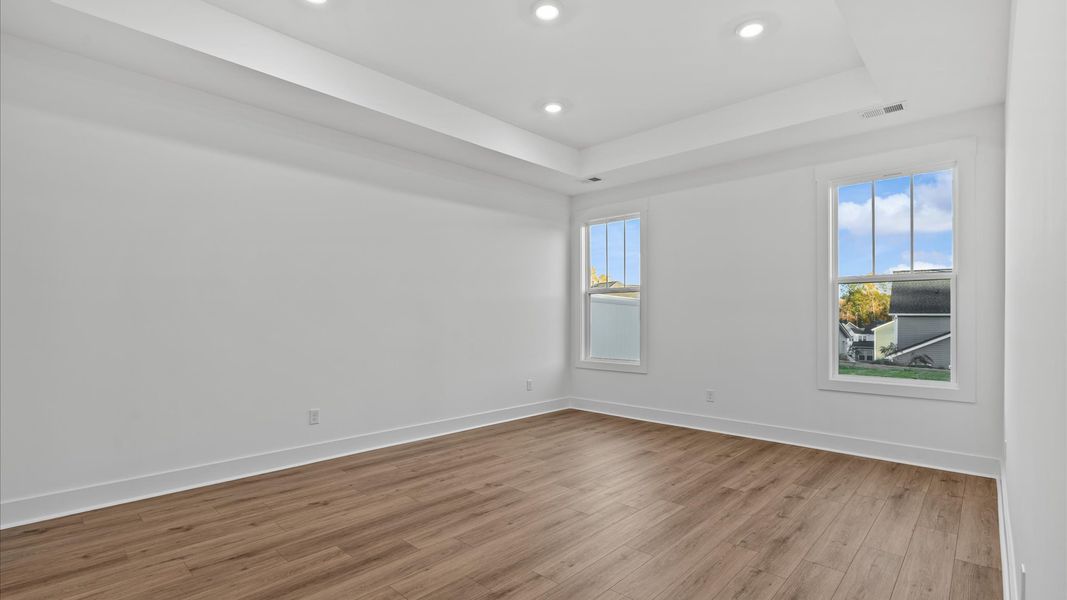 Eye-catching details and elegant finishes in this vibrant primary suite with tray ceiling