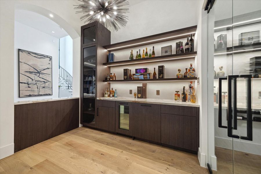 Experience the ultimate in hospitality with this custom crafted bar area, an elegant hanging chandelier and entertainment space