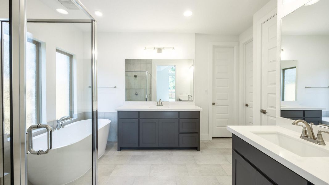 Full bathroom featuring a shower stall, a freestanding bath, two vanities, recessed lighting, and tile patterned flooring Full bathroom featuring a shower stall, a freestanding bath, two vanities, recessed lighting, and tile patterned flooring