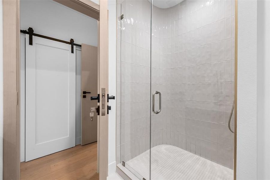 Bathroom with a shower stall and wood finished floors