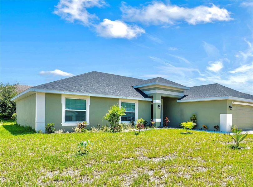 Front exterior of a new home in Poinciana Enclave, Kissimmee, FL, highlighting curb appeal (Image 15).