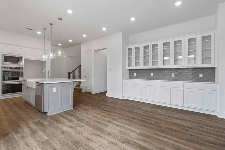 Kitchen featuring white cabinets, backsplash, hanging light fixtures, stainless steel appliances, and recessed lighting Kitchen featuring white cabinets, backsplash, hanging light fixtures, stainless steel appliances, and recessed lighting