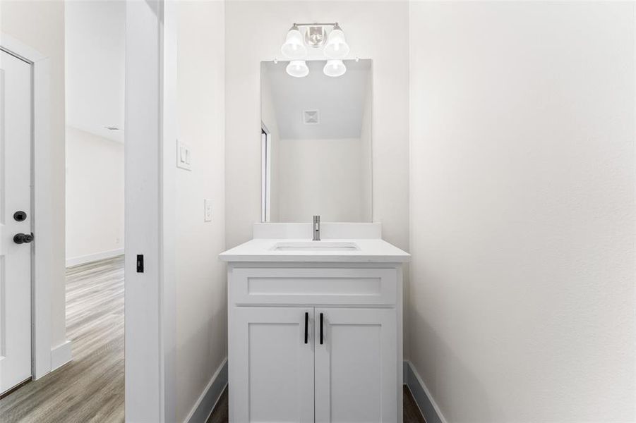 Half bathroom with vanity and dark wood-style flooring Half bathroom with vanity and dark wood-style flooring
