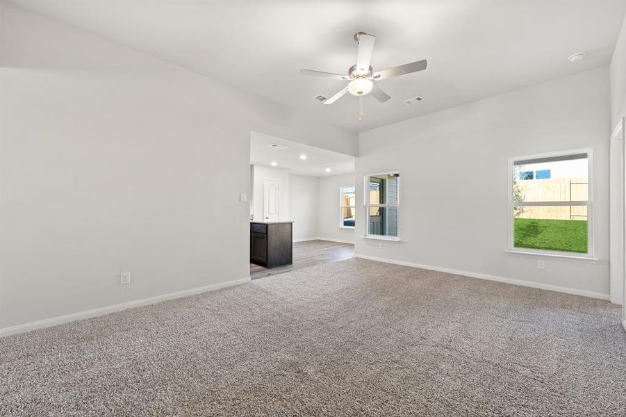 Unfurnished living room with ceiling fan and light carpet