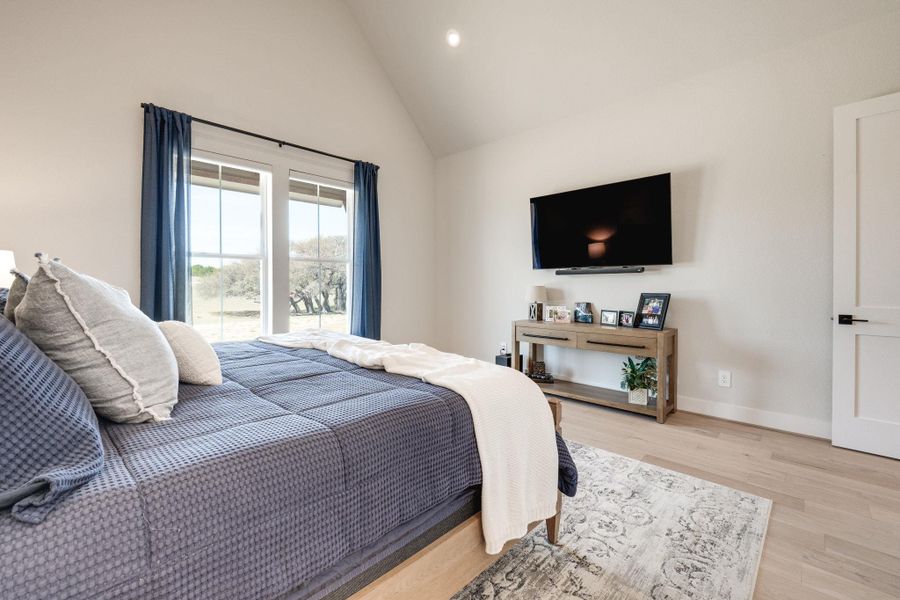 Bedroom featuring light wood finished floors, recessed lighting, and lofted ceiling