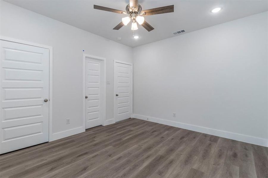 Unfurnished bedroom with ceiling fan and dark hardwood / wood-style flooring