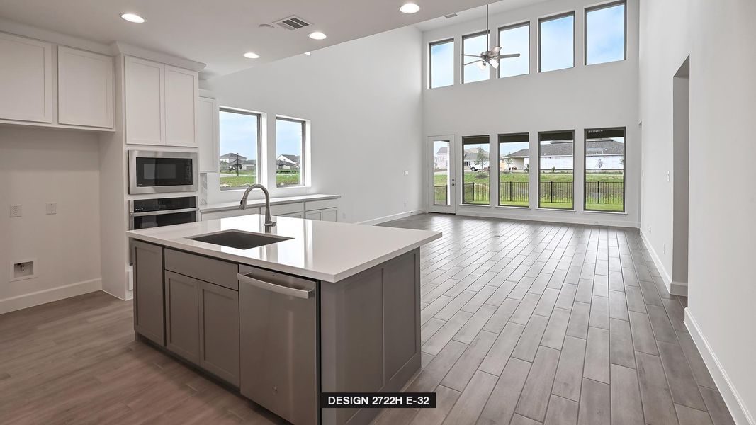 Kitchen featuring stainless steel appliances, open floor plan, a ceiling fan, light countertops, and dark wood finished floors
