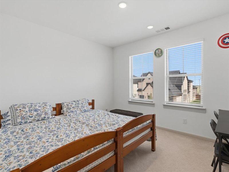 Double windows with horizontal blinds, recessed ceiling lighting, and carpeted flooring