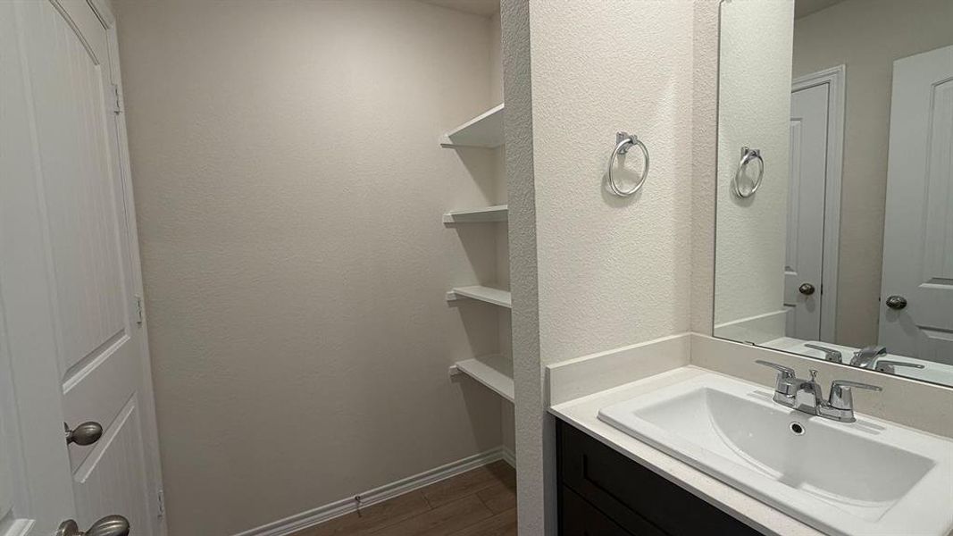 Vanity featuring a white countertop with an integrated sink, chrome faucet, and a large mirror