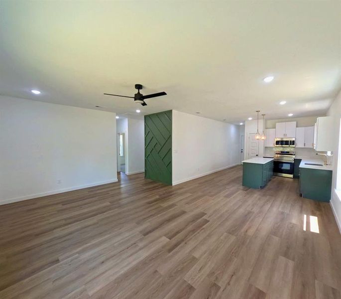 Unfurnished living room featuring recessed lighting, dark wood-type flooring, and a ceiling fan Unfurnished living room featuring recessed lighting, dark wood-type flooring, and a ceiling fan
