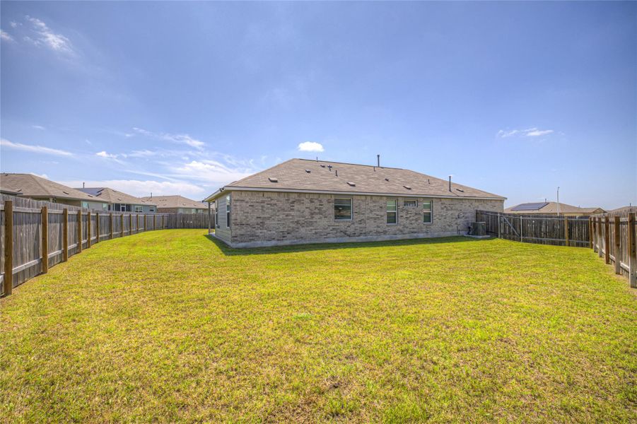 A spacious backyard with secure fencing offers ample room for outdoor activities.