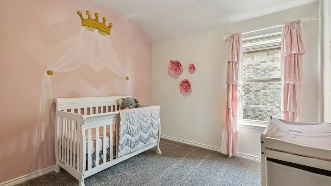 The property features a room with light grey carpet flooring, a window with blinds, and light-colored walls