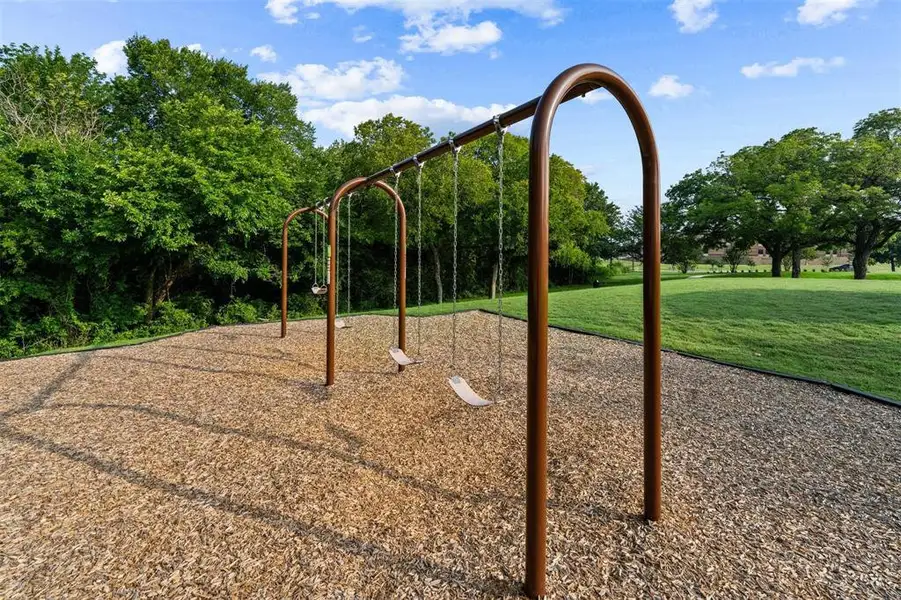 Community play area featuring a yard Community play area featuring a yard