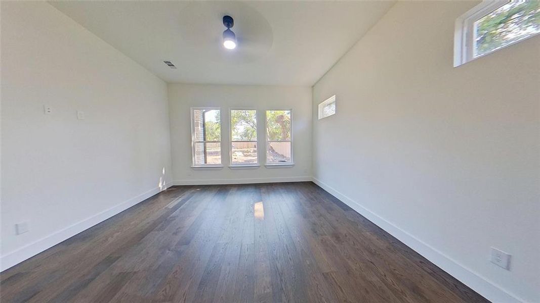 Unfurnished room with plenty of natural light, dark wood finished floors, and ceiling fan