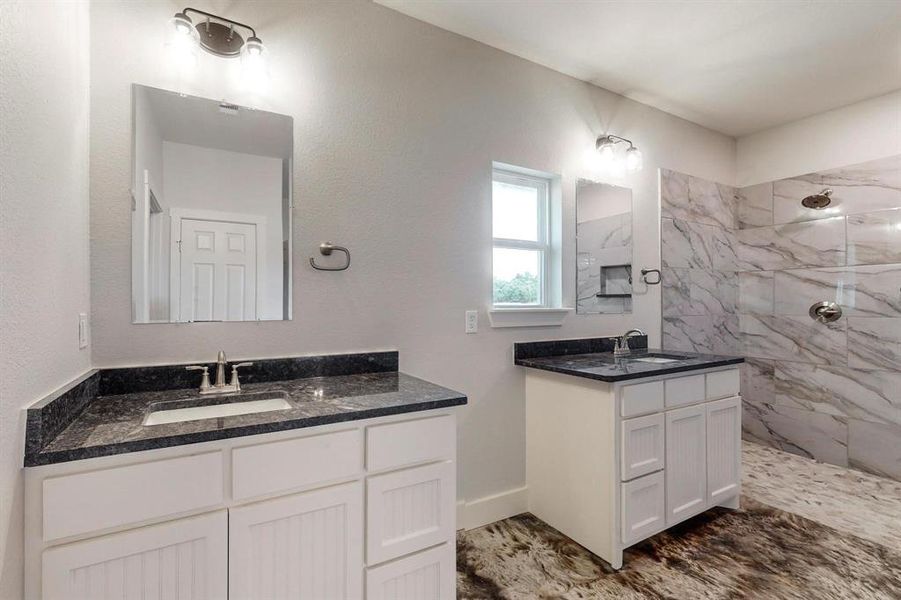 Bathroom featuring vanity and tiled shower