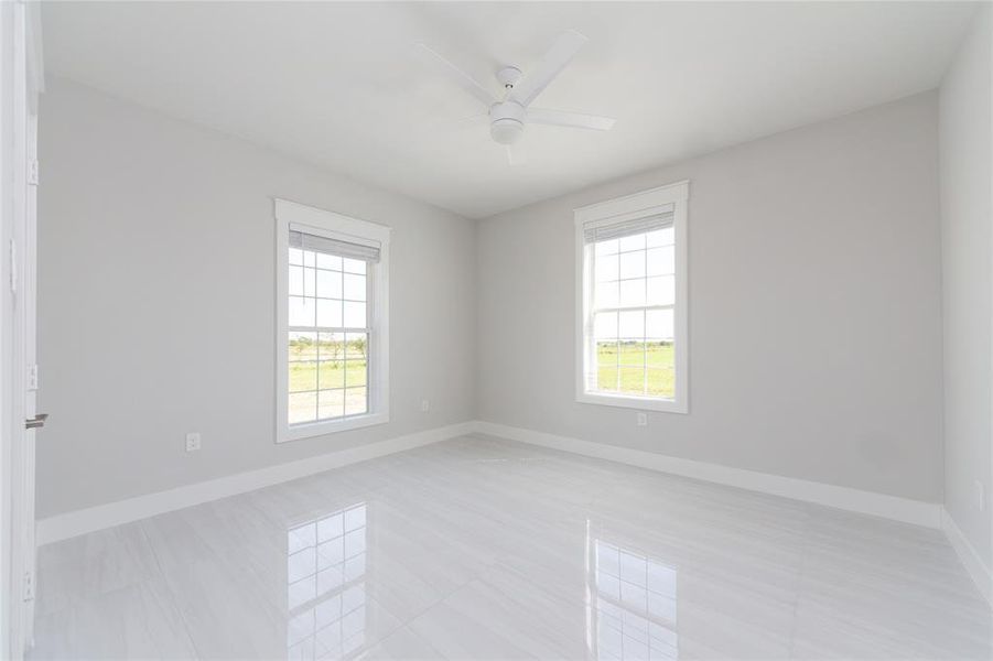 2nd Bedroom with ceiling fan and light tile patterned floors