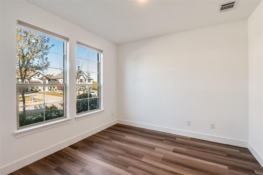 Empty room featuring dark wood-type flooring and baseboards Empty room featuring dark wood-type flooring and baseboards