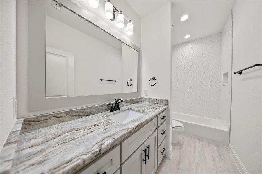 Bathroom featuring vanity, shower / washtub combination, and recessed lighting